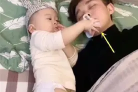 宝爸带娃睡觉鼾声如打雷，宝宝拽下袜子“警告”老爸：快点住嘴图片