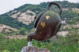 青岛一景区内，一把悬空的大茶壶水流不停，无数游客前来围观图片