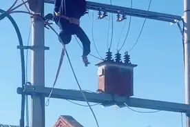 哈尔滨一男子高压电杆作业不慎触电，倒挂空中图片