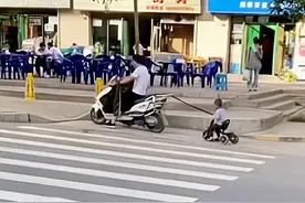 江苏一男子骑电动车，拉着骑儿童车的儿子：爸爸带娃，活着就行图片
