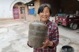 河滩发大水，6旬大妈地里捡到一个陶罐，想问下专家这东西值钱吗图片