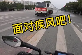 河南一男子骑摩托等红灯，突遇洒水车经过，司机的做法让他感动图片