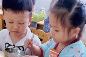 四川一幼儿园小男孩吃饭很慢，女孩主动给他喂饭，动作熟练又可爱图片