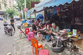 街边修鞋摊顾客寥寥无几，大妈绣鞋垫打发时间，盼着城市彻底复苏图片