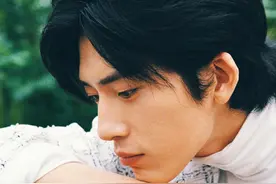 井柏然一袭白色粗呢外套，搭配白色高领内搭，置身盛放的石榴花间图片