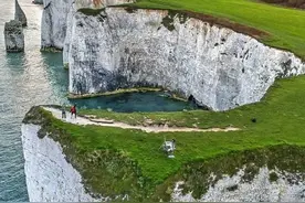 英国白崖·奶白色的岩壁上面覆盖着一层绿油油的草地图片
