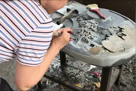 夫妻携手，用刀把一块厚厚的石头雕刻成茶盘，成品如同“山水画”图片