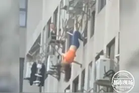 惊险！女子倒挂8楼窗外 仅靠一根晾衣架支撑 身体在空中晃荡图片