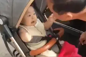 姥爷想要亲宝宝，但宝宝的反应很激烈，让站在一旁的妈妈忍俊不禁图片