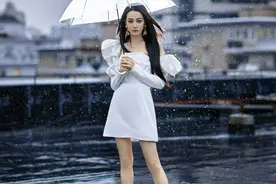 迪丽热巴白色泡泡袖抹胸裙秀美腿 撑伞伫立雨中优雅如公主图片