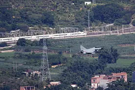 歼-10战机超低空飞行画面曝光：从居民楼顶掠过，与动车同框竞速图片