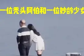 广东深圳，一位秃头大叔和一妙龄女子散步海边，女子时而撒娇卖萌图片