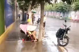 带娃出门遛弯突降大雨，可无处躲避，宝妈的反应惹路人泪目图片