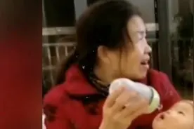 奶奶边看电视边喂奶，举着奶瓶娃却够不到，宝宝：太难了图片
