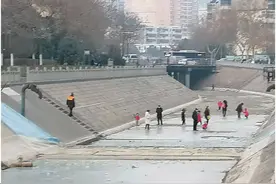 危险！郑州一河面结冰，多人踩冰玩耍图片