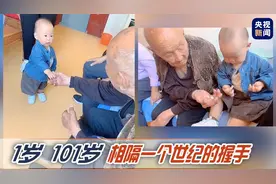 一个不懂世事 一个历经沧桑 萌娃与百岁老人的世纪握手图片