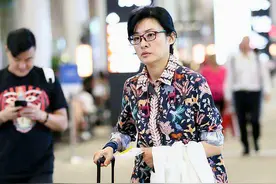 52岁周涛走机场，穿衬衫气质普通像大妈，九分裤里套丝袜暴露年龄图片