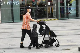 深圳街头随拍，一对母子俩戴口罩空旷处散步，小朋友紧贴妈妈图片