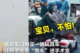 医院用玩具车接孩子进手术室，孩子坐在车上不愿下来图片