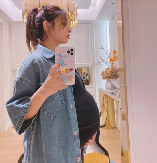 照片中麦迪娜肚子已经9个月大,拍照的时候还必须用手托着肚子.