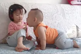 萌娃“偷吃”小姐姐棒棒糖走红，得逞后的“露齿笑”萌化了图片