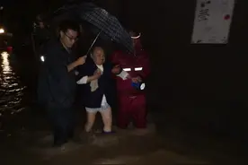 点赞！面对积水她脱下雨靴给老人穿 自己打赤脚图片