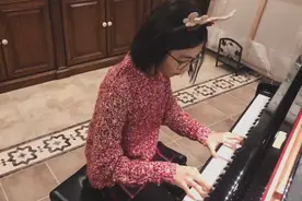 多多弹钢琴组曲过圣诞 穿红色毛衣戴鹿角很应景图片