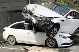 嘉定一小区内一轿车“骑”上另一辆车头 无人员伤亡图片