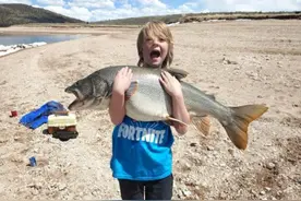 僵持15分钟后，美国11岁男童钓起近1米长鳟鱼图片