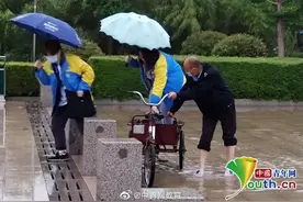 下雨积水，中学保安用脚蹬三轮车渡学生去教室图片
