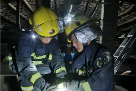 蟒蛇盘绕屋檐消防员迅速抓捕图片