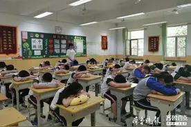 济南汇文实验学校小学生在座位上午休，老师送的靠枕派上了用场图片