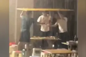 郑州男子和朋友顶着纸板在暴雨中吃饭，网友：大雨浇头照常喝视频封面