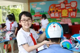 广东交通安全宣教进校园，小学生现场头盔手绘“一盔一带”图片