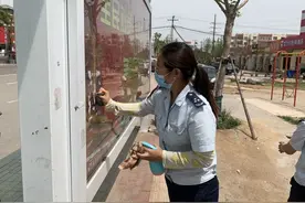 城阳巴士120路乘务员清理公交站台小广告 保持干净整洁等车环境图片