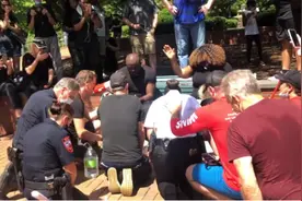 北卡罗来纳州示威游行：白人警察跪地为黑人牧师洗脚图片