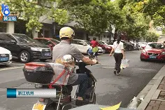 杭州街头爆笑一幕：大伯骑车给狗子戴自制头盔！评论亮了图片