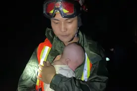 暖！消防员小哥哥怀抱新生婴儿涉水转移图片