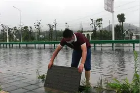 大雨中，公交线长脱掉鞋袜积水中清理污物图片