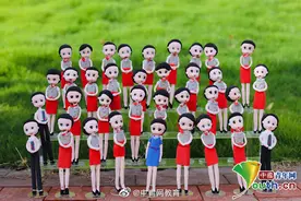 女大学生为全班同学捏制泥人形象，拍摄卡通毕业照图片