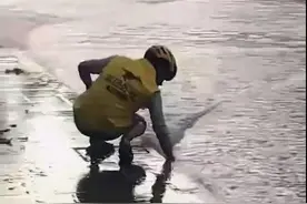 水漫路牙石，外卖小哥雨中徒手掏出排水口垃圾图片