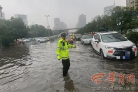 西安市北郊突降暴雨 未央交警淌水3小时疏通道路图片