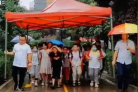 老师雨中撑起“超级大伞”护住小学生图片