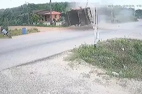 大难不死！泰国一少年骑摩托车被侧翻卡车压住瞬间跳下逃走图片