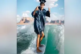 美国一高中生边冲浪边穿毕业服 拍出另类毕业照图片