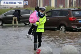 民警抱孩子趟过积水 他是风雨中最美“摆渡人”图片