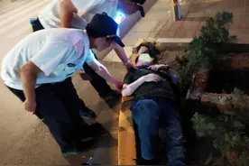 男子喝多后，倒在马路隔离花坛里呼呼大睡图片