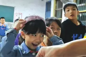 乡村教师给学生戴上新发箍；网友：视频看得笑着笑着就哭了，她们就像戴上皇冠那么骄傲图片
