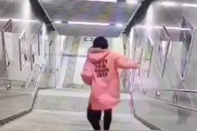 女孩地铁站内下楼梯时玩手机 脸朝下摔倒图片