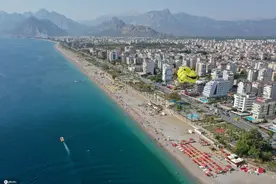 航拍土耳其地中海沙滩民众晒日光浴 巨型笑脸降落伞吸睛图片